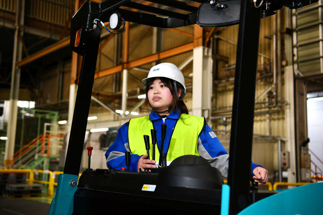フォーク運転中の女性先輩スタッフ